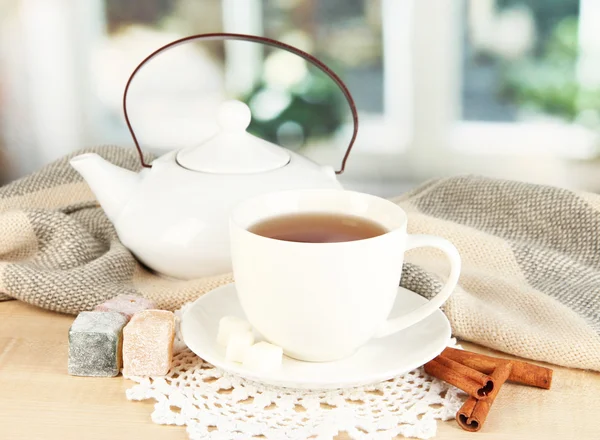 Tasse de thé avec écharpe sur la table dans la chambre — Photo