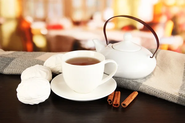 Cup of tea with scarf on table in room — Stock Photo, Image