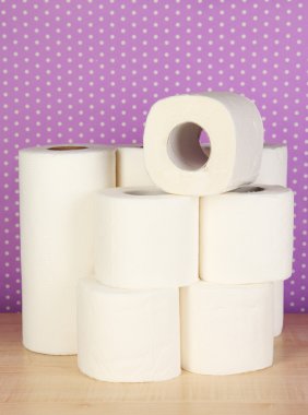 Rolls of toilet paper on purple with dots background