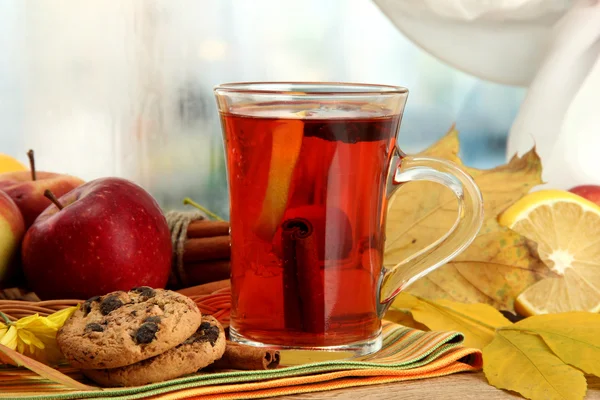 Kubek gorącej herbaty i liści jesienią, na drewnianym stole — Zdjęcie stockowe
