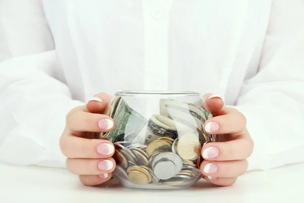 Vrouw handen met geld in glazen pot, close-up — Stockfoto