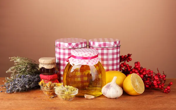Мед и другие природные лекарства для зимнего дымохода, на деревянном столе на коричневом фоне — стоковое фото