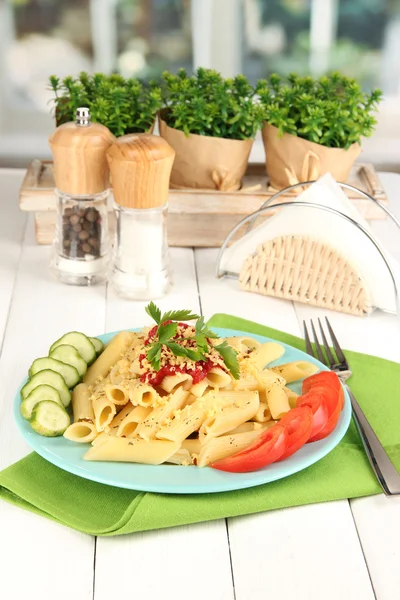 Těstoviny kolínka s rajskou omáčkou na bílý dřevěný stůl v kavárně — Stock fotografie