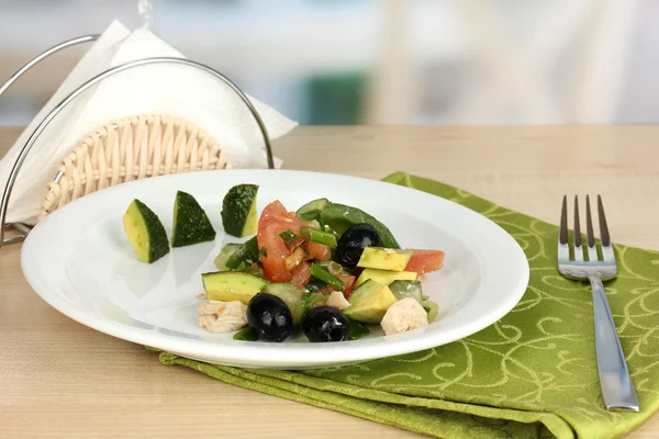 Tasty avocado salad in bowl on wooden table on restaurant background — Stock Photo, Image