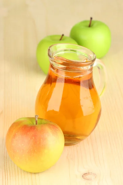 Full jug of apple juice and apple on wooden background — Stock Photo, Image