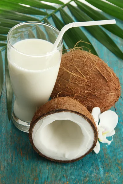 Cocos con vaso de leche, sobre fondo azul de madera —  Fotos de Stock