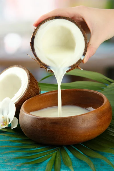 Noix de coco avec feuilles et fleurs, sur fond de bois bleu — Photo