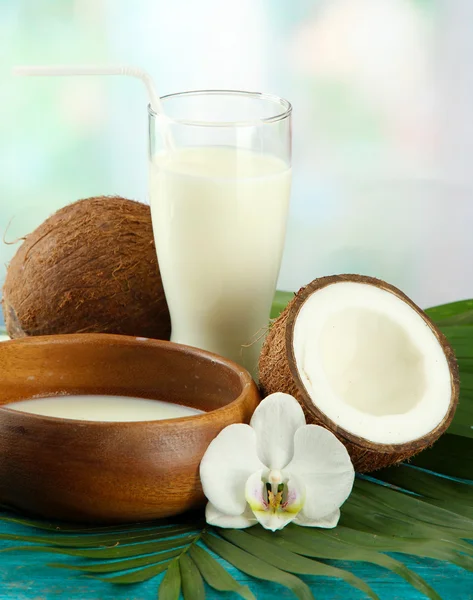 Kokos met glas melk, op blauwe houten tafel — Stockfoto