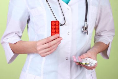 kadın doktor el hapları, renkli arka plan üzerinde tutarak yakın çekim