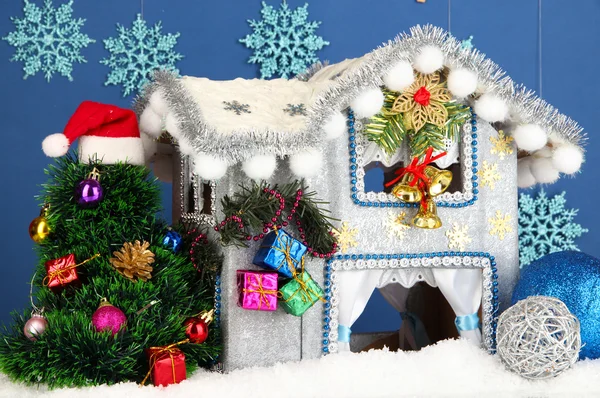 Διακοσμημένο χριστουγεννιάτικο σπίτι σε μπλε φόντο — Φωτογραφία Αρχείου