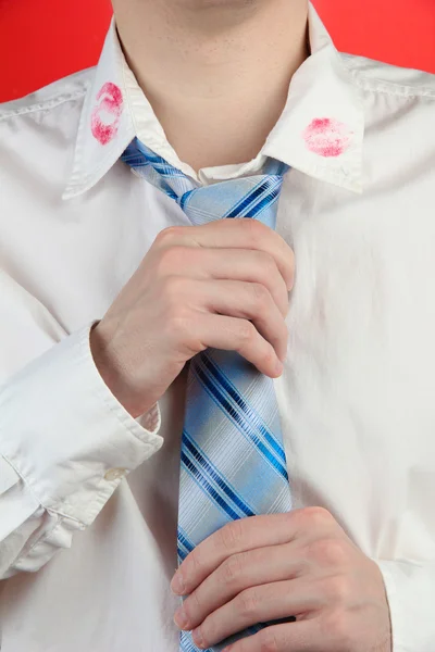 Beso de lápiz labial en el cuello de la camisa del hombre, sobre fondo rojo — Foto de Stock