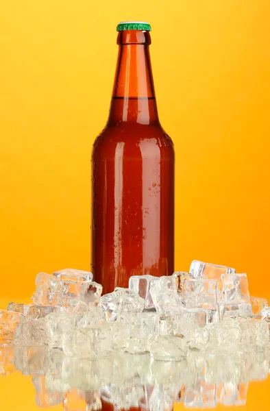 Botella de cerveza en hielo sobre fondo naranja — Foto de Stock