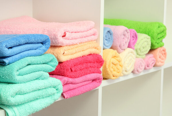 colorful towels on shelves in bathroom