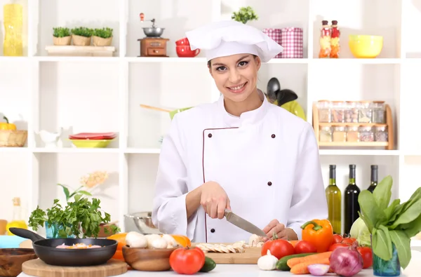 Young woman chef cooking in kitchen — Stock Photo, Image