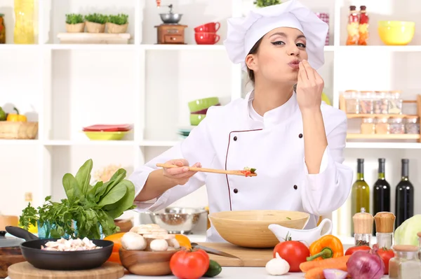 Young woman chef cooking in kitchen — Stock Photo, Image