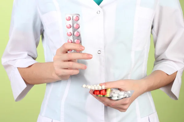 Nahaufnahme einer Ärztin, die Pillen in der Hand hält, auf farbigem Hintergrund — Stockfoto
