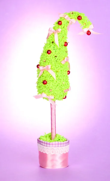 Julgran med böjd spets på lila bakgrund — Stockfoto