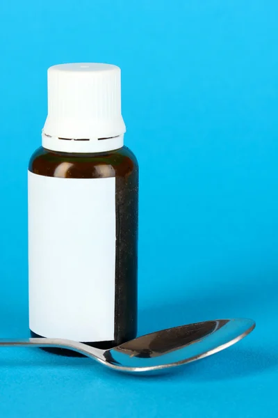 Medical drops and spoon for them on blue background — Stock Photo, Image