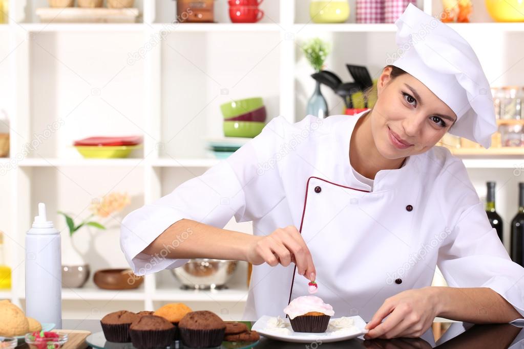 Young woman chef cooking cake in kitchen