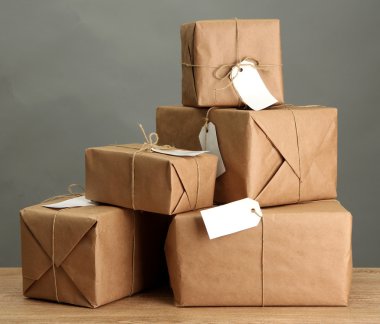 kutuları gri arka plan üzerinde ahşap masa hakkında kraft kağıt paketler