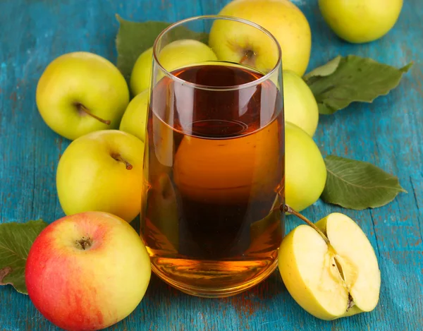 Användbara äppeljuice med äpplen runt på träbord — Stockfoto