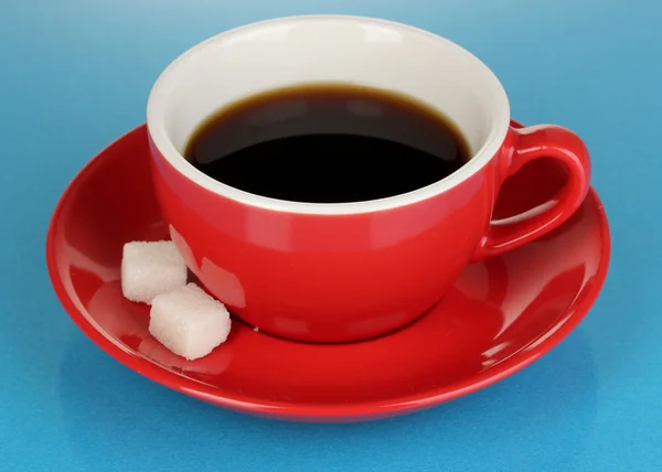 Una taza roja de café fuerte sobre fondo azul — Foto de Stock