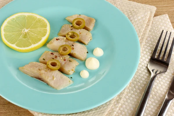 Ringa balığı ve limon plaka üzerinde ahşap masa yakın çekim yemek — Stok fotoğraf