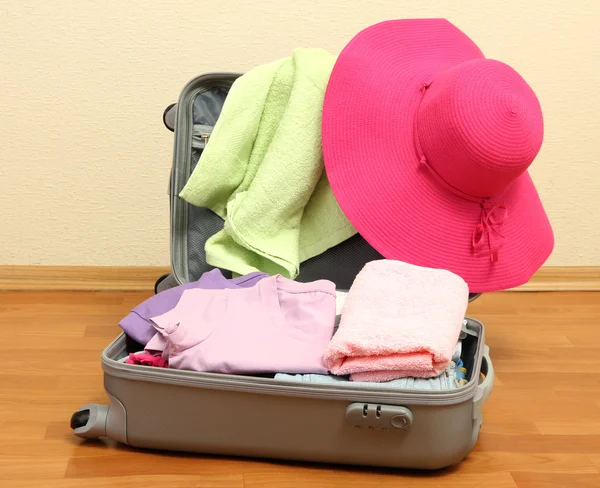 Avoin hopeinen matkalaukku vaatteet huoneessa — kuvapankkivalokuva