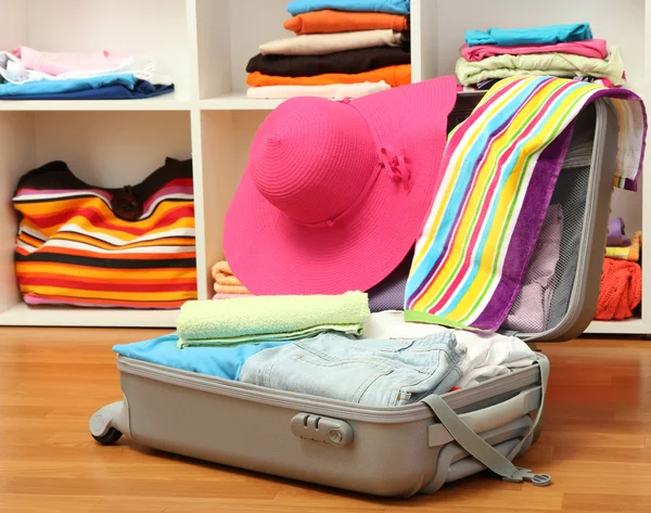 Ανοίξτε ασημένια βαλίτσα με τα ρούχα στο δωμάτιο — Φωτογραφία Αρχείου
