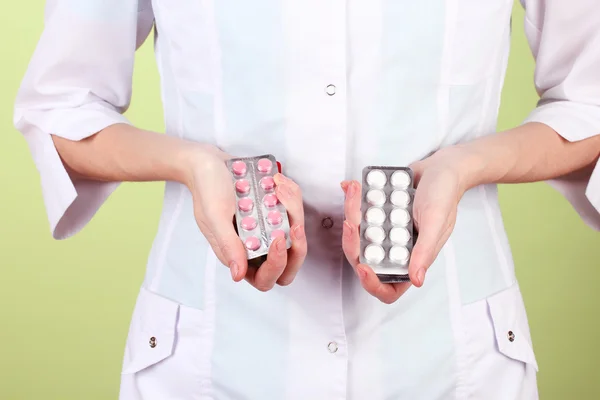 Primer plano de las píldoras de la mano del médico femenino, sobre fondo de color — Foto de Stock