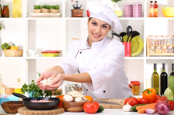 Young woman chef cooking in kitchen — Stock Photo, Image