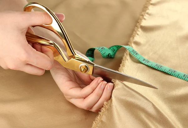 Seamstress cut gold fabric close-up — Stock Photo, Image