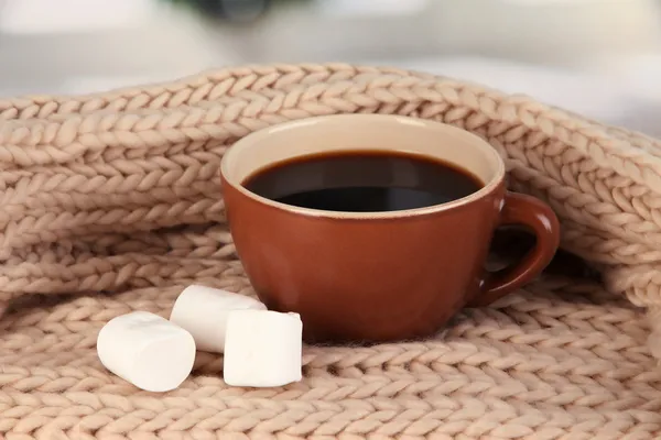 Kopp kaffe med halsduk på bord i rummet — Stockfoto