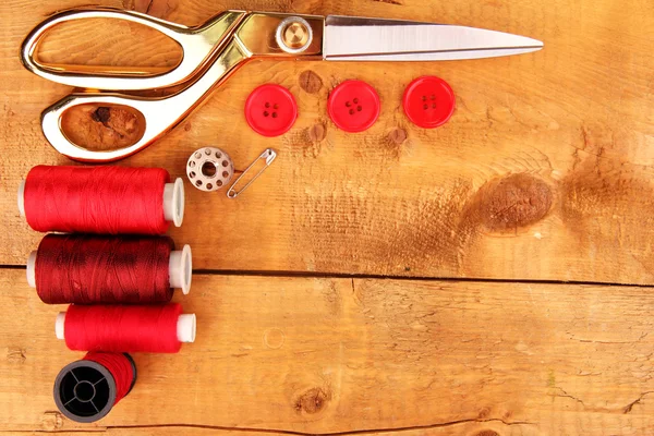 Naaien accessoires en stof op houten tafel close-up — Stockfoto