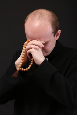 Genç papaz ile ahşap Tespihler, siyah üzerine izole
