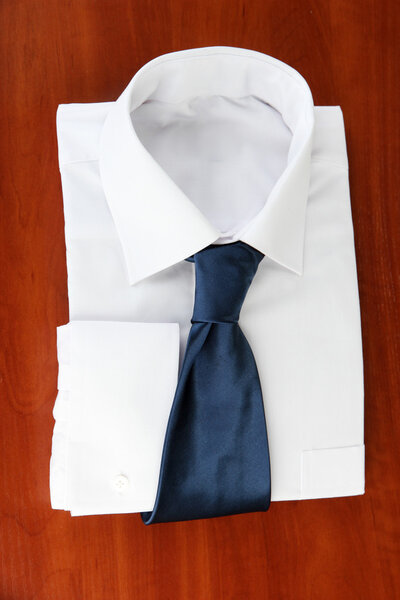 New white man's shirt with color tie on wooden background