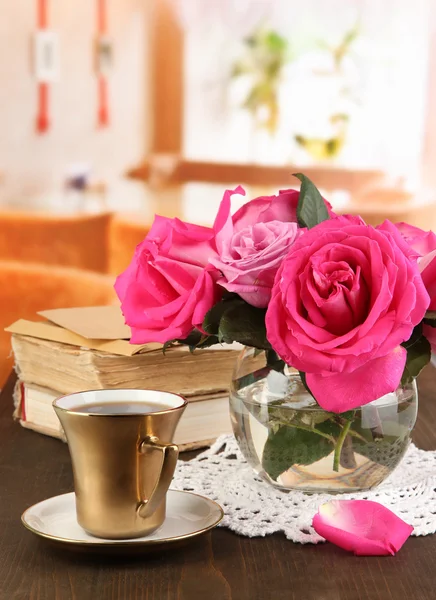 Mooie roze rozen in vaas op houten tafel op achtergrond van venster — Stockfoto