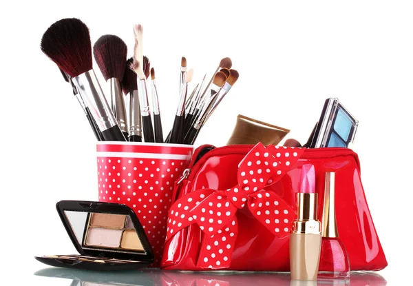 Vetro rosso con pennelli e borsa per il trucco con cosmetici isolati su bianco — Foto Stock