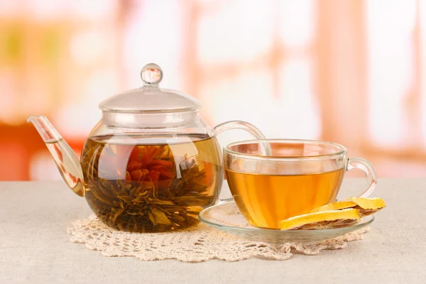 Exotische groene thee met bloemen in glas theepot op lichte achtergrond — Stockfoto