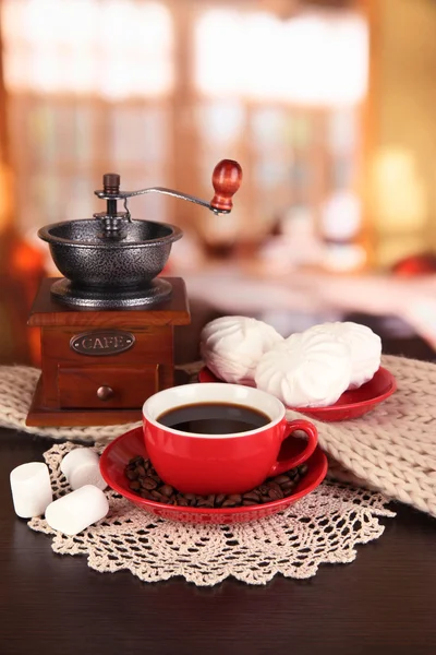 Kop kaffe med tørklæde og kaffemølle på bordet i rummet - Stock-foto