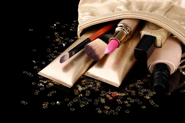 Torba piękny złoty makijaż i kosmetyki na czarnym tle — Zdjęcie stockowe
