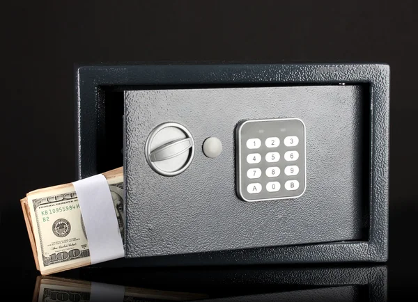 Money in open safe isolated on black — Stock Photo, Image