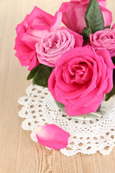 Hermosas rosas rosadas en jarrón en la mesa de madera de cerca —  Fotos de Stock