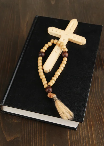 Bible, růženec a kříž na dřevěný stůl detail — Stock fotografie