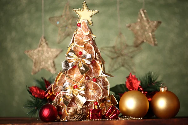 Prachtige Kerstboom van droge citroenen met decor, op grijze achtergrond — Stockfoto