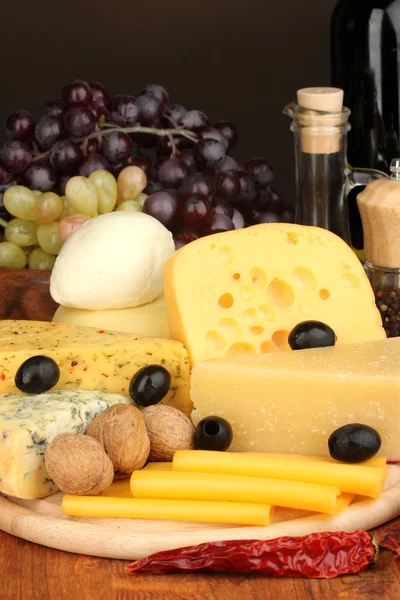 様々な種類のチーズが木の板に乗っています — ストック写真