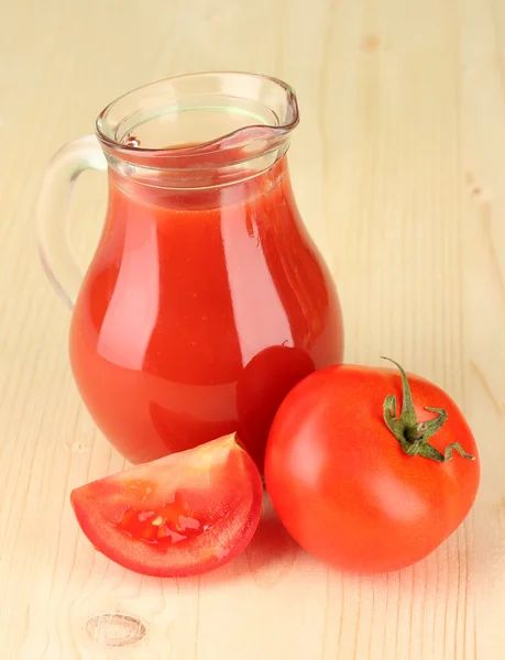 Jarra llena de jugo de tomate, sobre fondo de madera — Foto de Stock