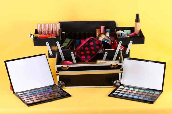 Open case with cosmetics on yellow background — Stock Photo, Image