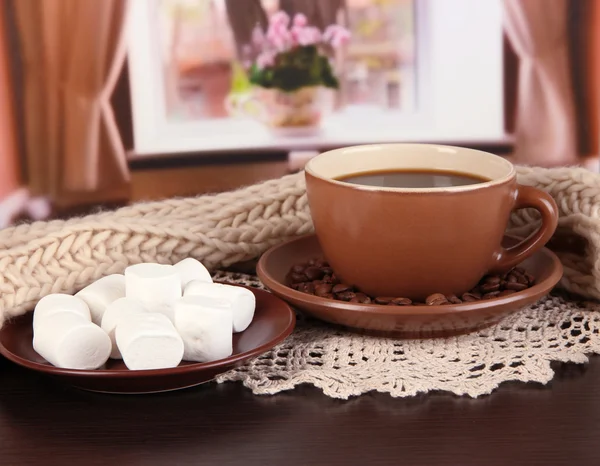 Tasse Kaffee mit Schal auf dem Tisch im Zimmer — Stockfoto