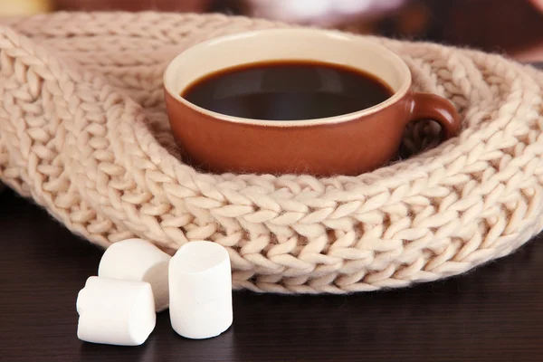 Tasse de café avec écharpe sur la table dans la chambre — Photo